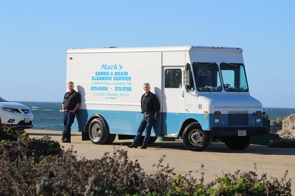 The Mark's Sewer & Drain crew standing in front of their service van on the Monterey coast